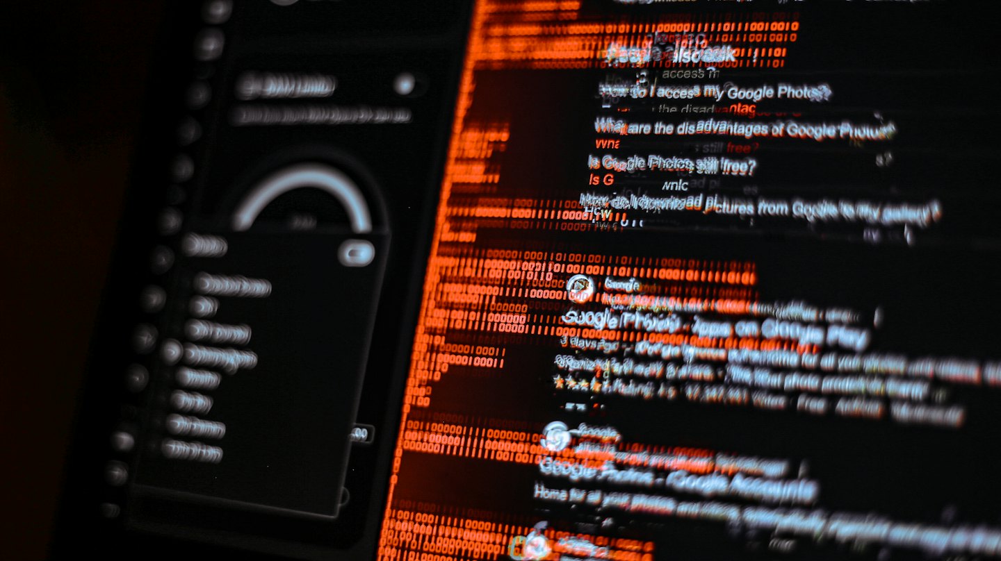 Digitální obrazovka zobrazuje fragmentovaná data a oranžový binární kód.